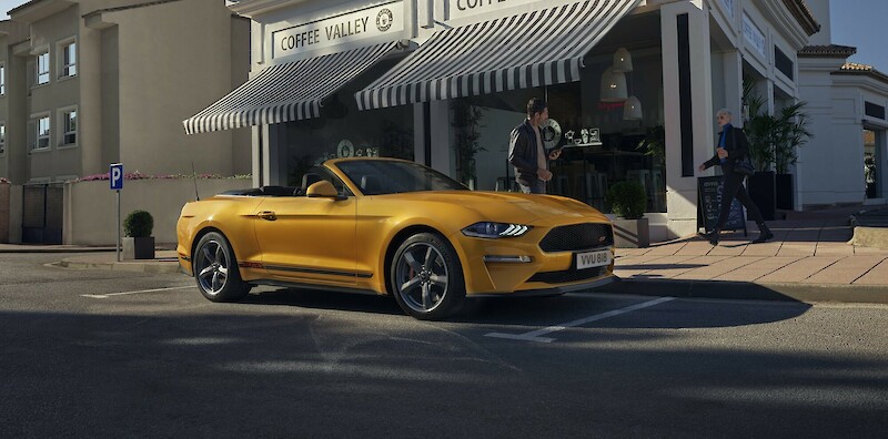 Sárga Ford Mustang áll a kávéző előtt az utcán