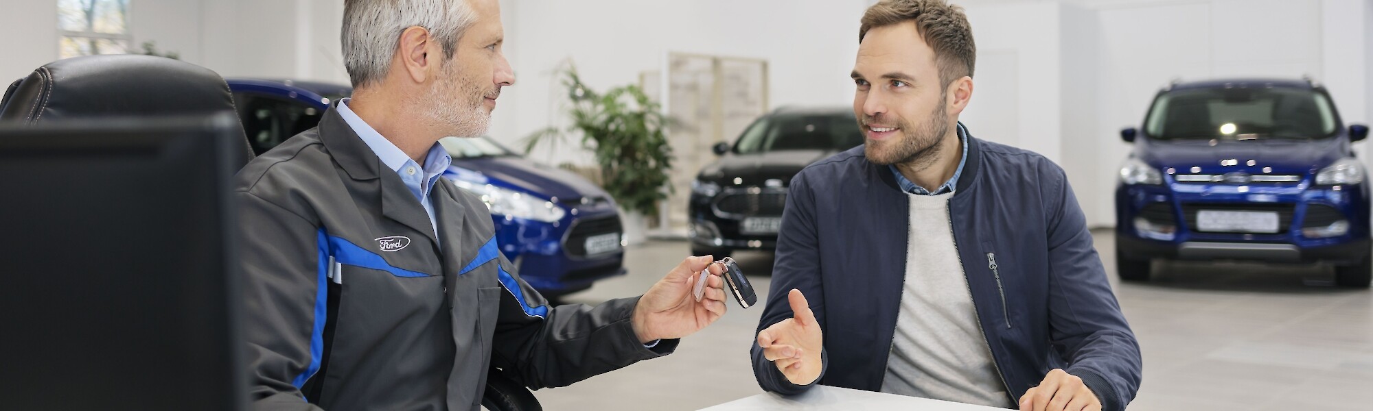 Ford szerelő és ügyfél beszélgetnek