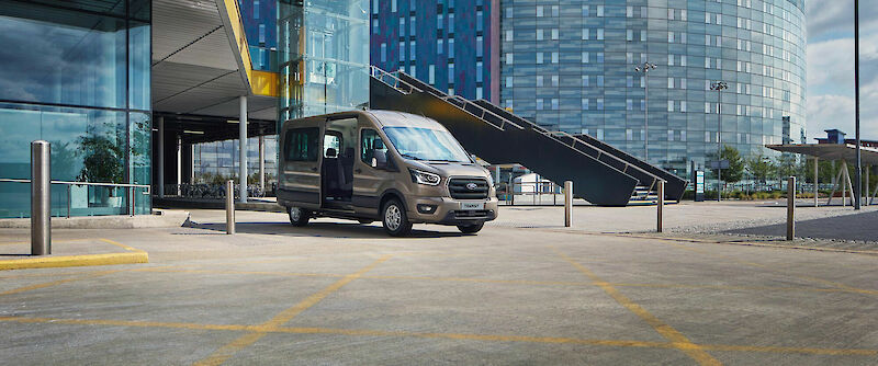 Ford Transit Minibusz áll egy épület előtt