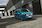 Kék Ford E-Transit Custom halad egy iparterületen