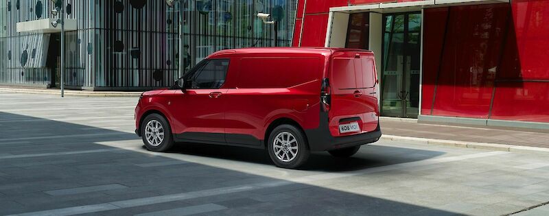 Ford Transit Courier modell parkol a piros épület előtt