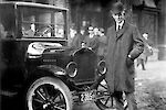 Henry Ford áll egy régi Ford modell mellett