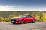 Ford Mustang áll a hegyvidéki erdős táj előtt