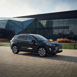 Ford Kuga áll egy üvegépület előtt