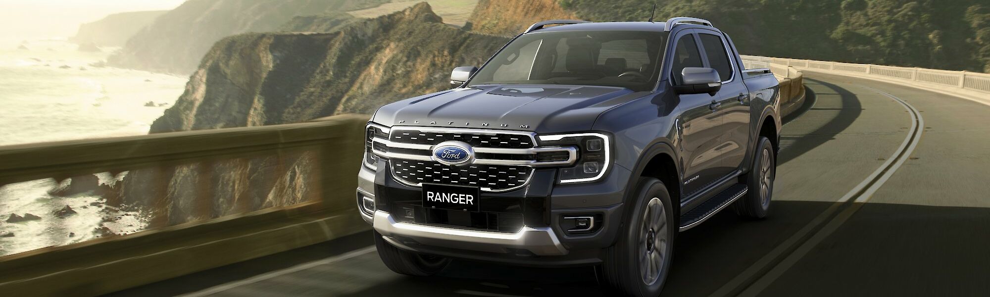 Ford Ranger Platinum halad a vízpart melletti dombos úton